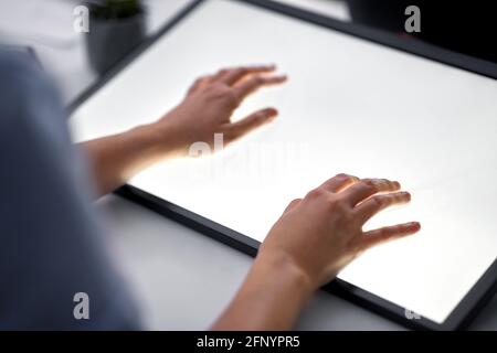 hands on led light tablet at night office Stock Photo