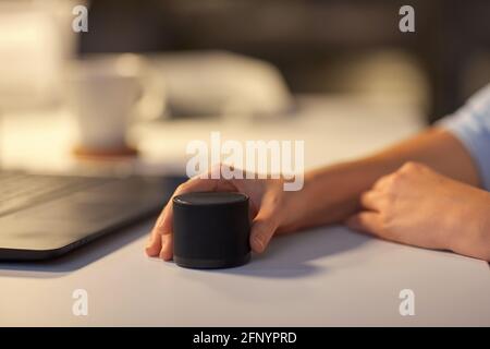 close up of hand with smart speaker at office Stock Photo