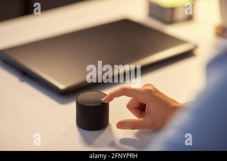 close up of hand with smart speaker at office Stock Photo