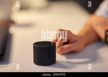 close up of hand with smart speaker at office Stock Photo