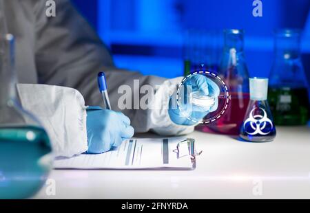 scientist with tests writing report of biohazard Stock Photo - Alamy