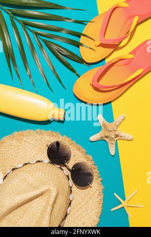 Flat composition with beach holiday accessories and palm leaf on colored background, summer background. Stock Photo