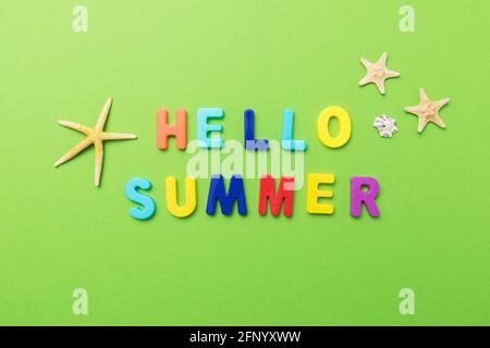 The inscription from multi-colored plastic letters with starfish on a green background. Stock Photo
