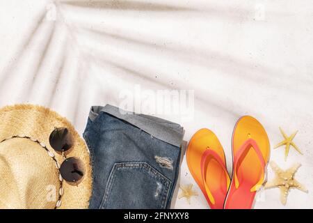 Womens straw hat, sunglasses, shorts and flip flops on a light background with copy space, summer background. Stock Photo