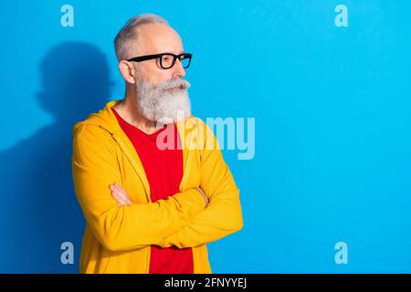 Photo of focused representative mature man in glasses look copyspace with crossed arms isolated on blue color background Stock Photo