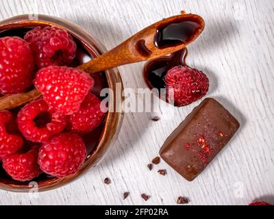 Dark handmade chocolate with raspberries and syrup Stock Photo