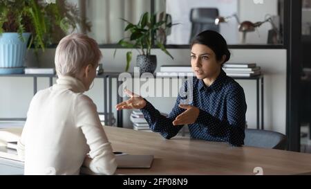 Multiracial female business partners talk at office meeting Stock Photo