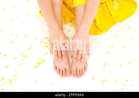 Unrecognizable female sitting with golden glittering stars scattered on floor around room lit by sunlight Stock Photo