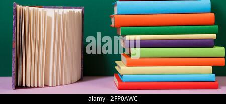 Composition with vintage old hardback books, colored background. Books stacking. Back to school. Copy Space. Education background. Stock Photo