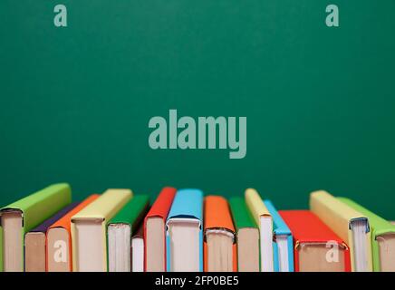 Composition with vintage old hardback books, colored background. Books stacking. Back to school. Copy Space. Education background. Stock Photo