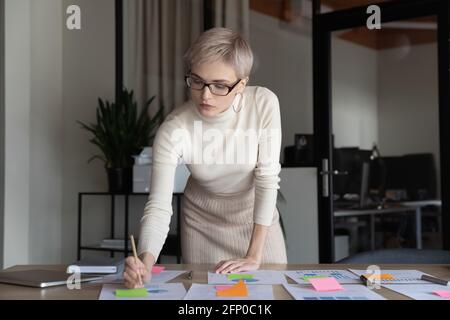 Confident businesswoman busy working with financial paperwork Stock Photo