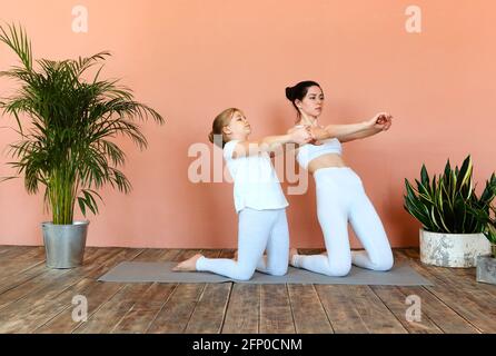 A Little Girl In Black Sportswear, Practicing Yoga, Performs The