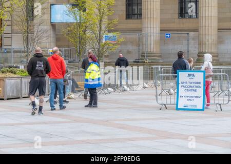 Members of the public queue at a mass NHS Tayside covid-19 vaccination centre, at the Caird Hall, City Square, Dundee, Tayside, Scotland.