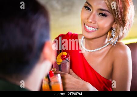 Asian couple drinking cocktails in fancy bar Stock Photo