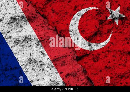 Concept of the Conflict between Turkey and France with painted Flags on a Wall and a Crack between them Stock Photo