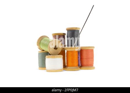 Wooden bobbins for gray, orange, burgundy, purple threads on white isolated background. Handmade, needlework, sewing items. Copy space Stock Photo