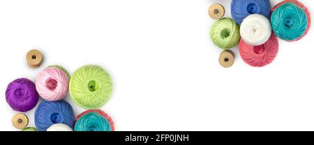 Multicolored balls and bobbins of woolen yarn, wooden thread sleeves on white isolated background. Banner for needlework, handmade. view from above. I Stock Photo