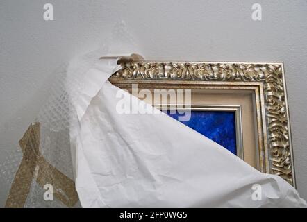 unwrapped painting leaning against the wall Stock Photo