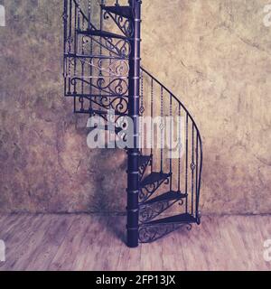 Retro cast iron spiral staircase on the background of an old wall and floor boards Stock Photo