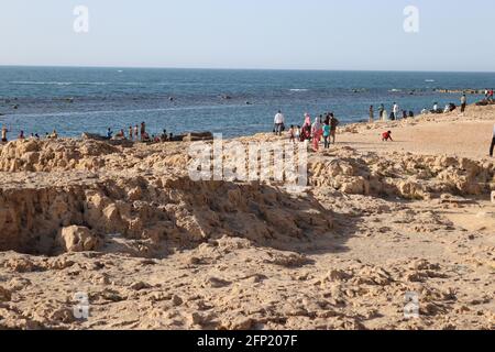 In Alexandria Egypt on the sea there are people, cliff, marine eagle, rocks, young men swimming on the sea with seascape, and beauty nature. Stock Photo