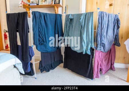 Clothes on a drying rack in a bedroom Stock Photo