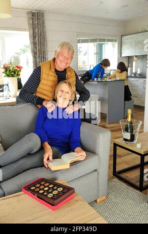 A retired couple spending time with their grandchildren on a holiday in Cornwall UK. The couple relax in a holiday apartment. Stock Photo