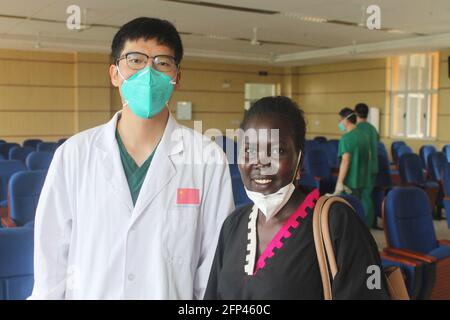 Juba, South Sudan. 19th May, 2021. Li Jinkuan (L), a Chinese language teacher, and Shida Joseph Yacoub, a psychologist at Juba Teaching Hospital, pose for a photo at the hospital in Juba, capital of South Sudan, May 19, 2021. South Sudanese health workers have started learning the Chinese language at Juba Teaching Hospital in the country's capital city. This will strengthen collaboration between local staff and Chinese doctors in the country.TO GO WITH 'Feature: South Sudan health workers emboldened to learn Chinese language' Credit: Denis Elamu/Xinhua/Alamy Live News Stock Photo
