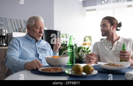 Grandfather and grandson talking at table Stock Photo