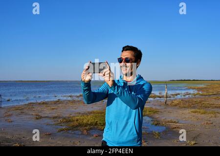 Young man smiling while taking a picture Stock Photo