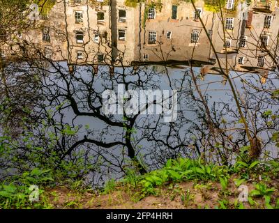 Houses reflected in the calm water of the River Derwent at Matlock Bath a village in the Derbyshire Dales area of the Peak District England UK Stock Photo