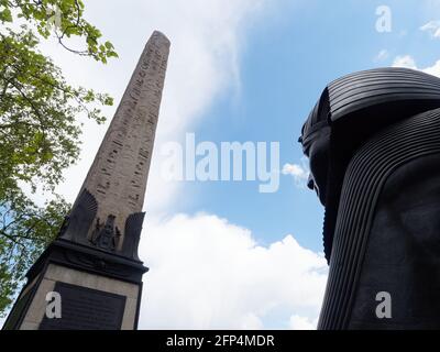 London, Greater London, England - May 18 2021: Cleopatras Needle an Eqyption Obelisk and a bronze Spinx statue near Embankment Gardens. Stock Photo