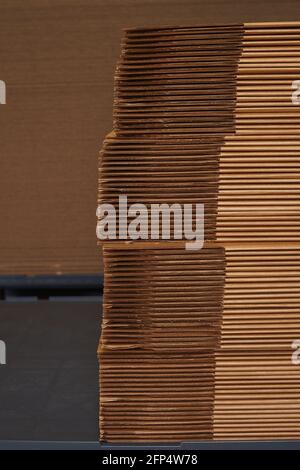 Stack of cardboard packaging folded in sheets in a factory. Stock Photo