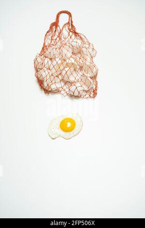 scrambled eggs with whole yolk and broken shells in net bag Stock Photo