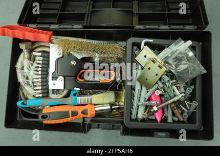 Open large black box for construction tools. Carrying case with many tools on gray background Stock Photo