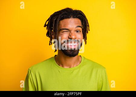 Portrait of nice satisfied dark skin guy wink eye in camera isolated over vibrant yellow color background Stock Photo