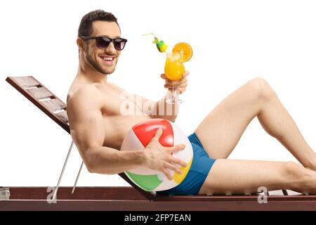 Man in swimming suit holding an inflatable ball and a cocktail isolated on white background Stock Photo