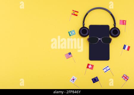 Travel concept - sunglasses, tablet or phone, headphones with flags of different countries Spain Israel USA China Great Britain France Korea on a brig Stock Photo
