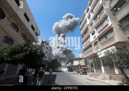 Smoke rises from a 14-story building as Israeli fighter jets continue to pound a Palestinian building called 'Ash-Shuruq' at Omar Al-Mukhtar neighborhood. Gaza Strip. Stock Photo