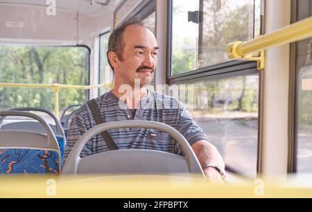 Portrait of senior Asian man in public transport.