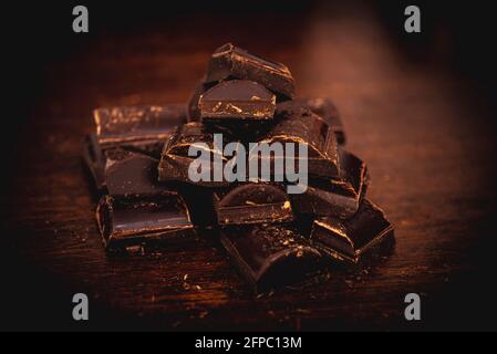 Bitter chocolate with peanuts in bar on dark background with illuminated light Stock Photo