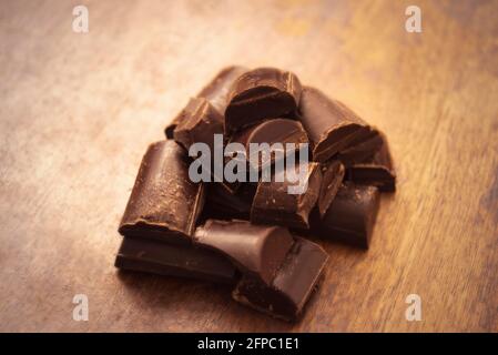 Sweet dark chocolate Bitter chocolate with peanuts in bar on dark background with illuminated light Stock Photo