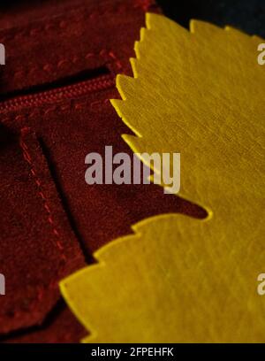 yellow maple leaf coaster on a red fabric background Stock Photo