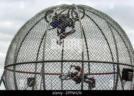 Globe of death, motorcycle riders stunt riding inside a globe. Motorbike stunt motorcyclists inside a mesh sphere ball. Circus, carnival show display Stock Photo