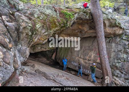 Visitors explore the entrance of Robbers Cave at Robbers Cave State Park in Wilburton, Oklahoma. (Photo by Michael Woods, michaelwoodsphoto.com) Stock Photo