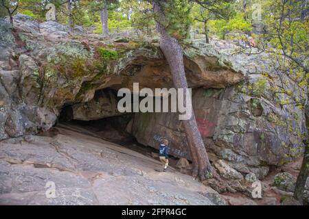 Visitors explore the entrance of Robbers Cave at Robbers Cave State Park in Wilburton, Oklahoma. (Photo by Michael Woods, michaelwoodsphoto.com) Stock Photo