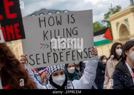 Demosntrantin hält ein Schild mit der Aufschrift: ' Wie kann Kinder töten Selbstverteidigung sein? ' Ca. 600 Menschen versammelten sich am 20.5.2021 in München, um ihre Solidarität mit den Menschen in Gaza, Ost Jerusalem, den besetzten Gebieten und dem Westjordanland zu zeigen. - Protestor holds sign reading: ' How is killing kids self defense? ' Around 600 people gathered on May 20, 2021 in Munich, Germany to show their support for the people in Gaza, East Jerusalem, the occupied territories and the Westbank. (Photo by Alexander Pohl/Sipa USA) Credit: Sipa USA/Alamy Live News Stock Photo