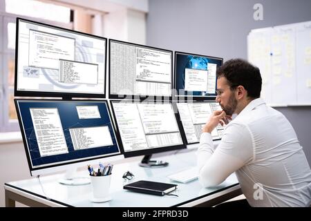 Software Developer Programming On Computer Monitor Screens Stock Photo