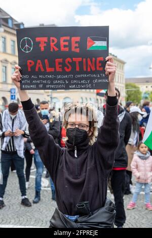 Demonstranitn hält Schild mit Aufschrift: ' Free Palestine/Stoppt alle militärische Zusammenarbeit und Handel mit Apartheid Israel & ähnlichen kriminellen Regimen der Unterdrückung weltweit! ' Ca. 600 Menschen versammelten sich am 20.5.2021 in München, um ihre Solidarität mit den Menschen in Gaza, Ost Jerusalem, den besetzten Gebieten und dem Westjordanland zu zeigen. - Around 600 people gathered on May 20, 2021 in Munich, Germany to show their support for the people in Gaza, East Jerusalem, the occupied territories and the Westbank. (Photo by Alexander Pohl/Sipa USA) Stock Photo