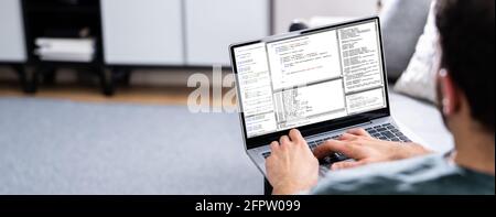 Computer Programmer Using Development Software On Laptop Stock Photo