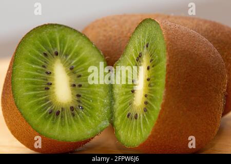 Ripe brown sliced kiwi on table ready for morning vitamin. Stock Photo